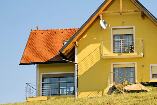 Gelbes Wohngebäude mit Holzfenstern